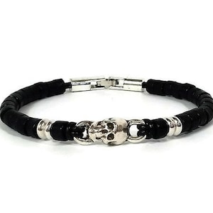 May include: A black beaded bracelet with a silver skull charm and a silver clasp.