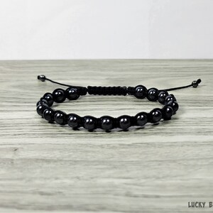 Puede incluir: Un brazalete negro de cuentas con un cord&oacute;n negro y un cierre de nudo deslizante.