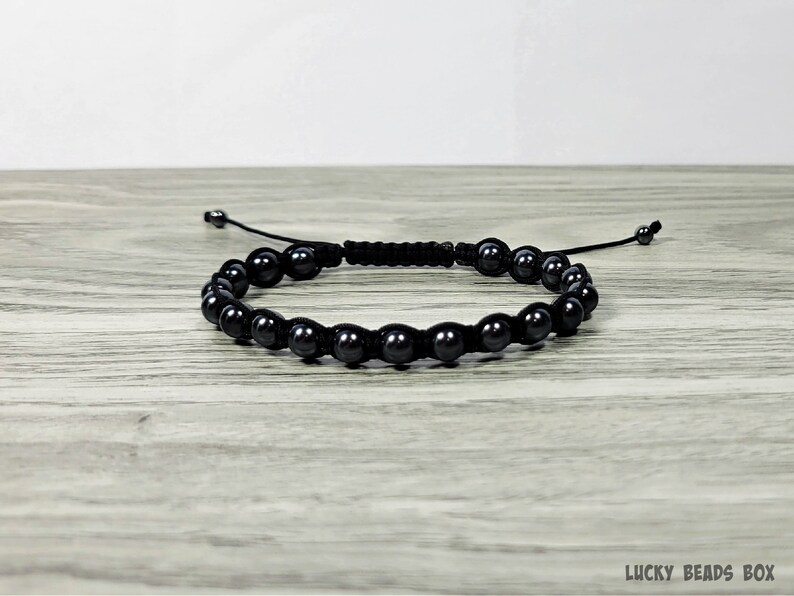 Puede incluir: Un brazalete negro de cuentas con un cord&oacute;n negro y un cierre de nudo deslizante.