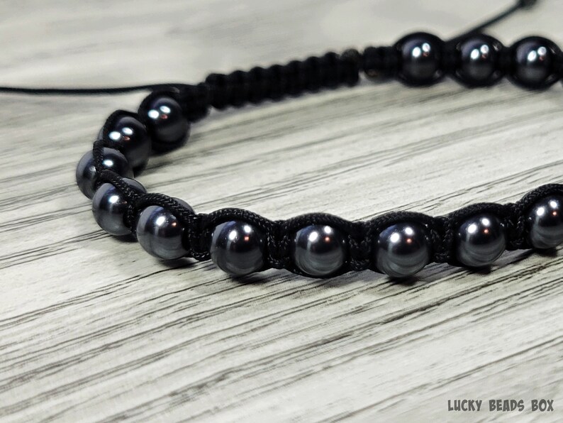 Puede incluir: Un brazalete negro con cuentas negras y un cord&oacute;n negro. Las cuentas son redondas y tienen un ligero brillo.