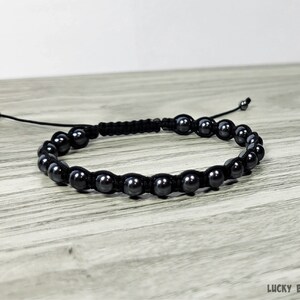 Puede incluir: Un brazalete negro con cuentas negras. Las cuentas son redondas y tienen un acabado mate.