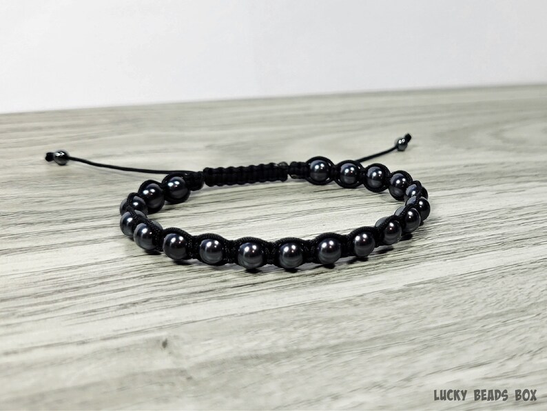 Puede incluir: Un brazalete negro con cuentas negras. Las cuentas son redondas y tienen un acabado mate.