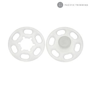 May include: Two white plastic snap fasteners, one with a raised center and the other with a ring of holes.