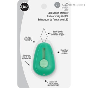 May include: Green LED needle threader with a built-in thread cutter. It has a finger grip, a lanyard hole, and a light to help you see the needle.  "LED Needle Threader Enfileur d'aiguille DEL Enhebrador de Agujas con LED" is printed on the packaging.