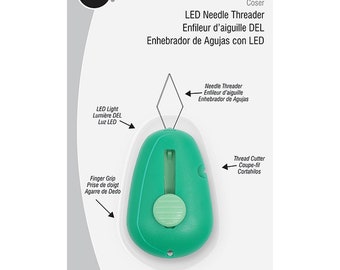 Könnte beinhalten: Grüner LED-Nähfaden-Einfädler mit integriertem Fadenabschneider. Er hat einen Fingergriff, eine Schlaufe für ein Band und ein Licht, das Ihnen hilft, die Nadel zu sehen.  "LED Needle Threader Enfileur d'aiguille DEL Enhebrador de Agujas con LED" ist auf der Verpackung aufgedruckt.