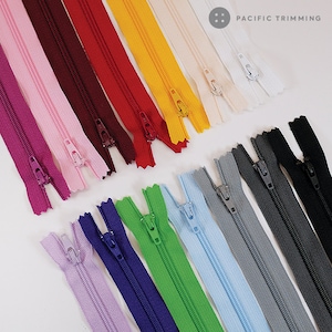 May include: Assortment of 14 zipper tapes in various colors, including pink, red, yellow, white, black, green, blue, and purple.  The zipper tapes are laid out in rows on a white surface.  PACIFIC TRIMMING is printed in the top right corner of the image.