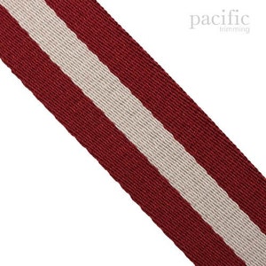 Peut inclure: Ruban en sangle rayé rouge et blanc. Le ruban est tissé avec un fond rouge et une bande blanche qui descend au centre.