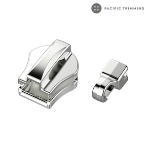 Op de afbeelding: Zilveren rits met een schuif en een treklip. De treklip is een apart onderdeel dat aan de schuif wordt bevestigd.