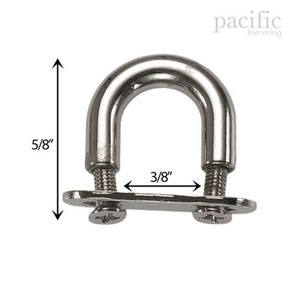 Può includere: Un anello a D in metallo argentato alto 1,6 cm e largo 1 cm. L'anello a D ha una base piatta con due viti.
