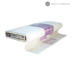 Könnte beinhalten: Eine Rolle weißer Heat-Bond-Vliesofix, eine Art von Einlage, die für Bastel- und Nähprojekte verwendet wird. Das Etikett lautet "Heat-Bond Medium Weight".