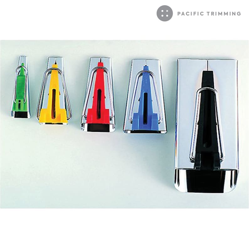 May include: Five seam rippers with different colored handles. The handles are green, yellow, red, blue, and black. The seam rippers are made of metal and have a sharp point. The seam rippers are arranged in a row from left to right. The seam rippers are all the same size. The seam rippers are all made by Pacific Trimming.