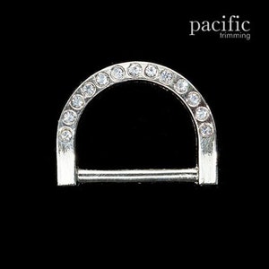May include: Silver-toned metal D-ring with a row of clear rhinestones around the top edge.  The ring is designed for attaching to a strap or chain.