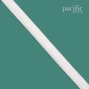 May include: White hook and loop tape on a teal background. The tape is textured and has a slight sheen. The text "pacific trimming" is in the upper right corner of the image.
