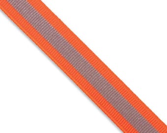 Könnte beinhalten: Ein Streifen aus leuchtend orangefarbenem Ripsband mit einem mittig verlaufenden, glatten, hellgrauen reflektierenden Streifen über die gesamte Länge. Das Band weist eine ausgeprägte gerippte Textur auf den orangefarbenen Teilen auf.