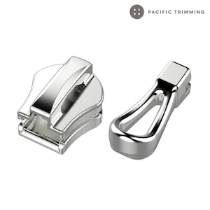 May include: Two silver zipper pulls, one with a slider and one with a loop. The slider is a simple, rectangular shape with a small, raised lip on the top. The loop is a more elaborate design with a rounded, oval shape and a small, raised lip on the top.