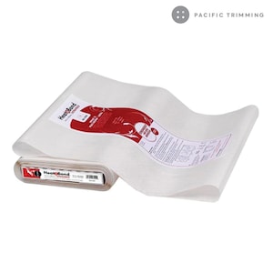 May include: A roll of white HeatnBond fusible web, a type of iron-on adhesive used for crafts and sewing projects. The roll is labeled with the HeatnBond logo and instructions for use.