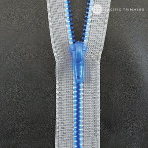 May include: A close-up of a zipper with a blue slider. The zipper tape is gray with a blue and silver thread running along the center.