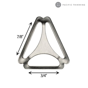 Op de afbeelding: Zilverkleurige metalen driehoekige gesp met een zijde van 2,2 cm en een basis van 1,9 cm. De gesp heeft een open ontwerp en wordt waarschijnlijk gebruikt voor riemen of andere bevestigingen. De tekst "PACIFIC TRIMMING" staat rechtsboven.