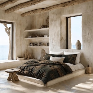 May include: A bedding set featuring a dark brown and black mottled pattern on the duvet cover and matching pillowcases, paired with solid white pillows, resting on a low platform bed frame in a room with textured beige walls and wooden beams.