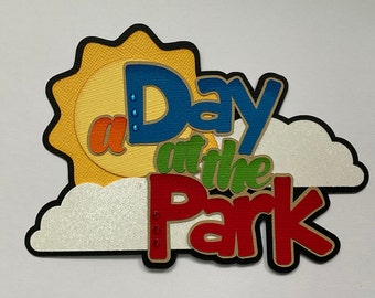 May include: A colorful paper craft with a sun, clouds, and the text "a Day at the Park".