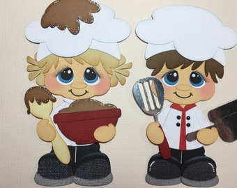 May include: Two cartoon chefs, one holding a bowl and spoon, the other a spatula and rolling pin. Both wear white chef hats and coats with black pants and shoes. The chef on the left has blonde hair, and the chef on the right has brown hair.