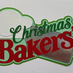 May include: Green and red paper craft with the words "Christmas Bakers" and a silver baking pan.
