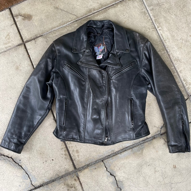 May include: A black leather motorcycle jacket with a zipper closure and multiple pockets.