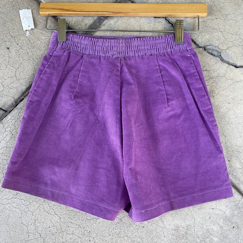 May include: Purple corduroy shorts with a wide elastic waistband.