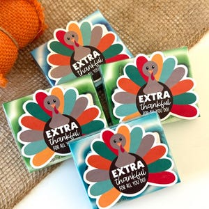 May include: Four small boxes with a colorful turkey design and the text "EXTRA thankful for all you do" on each box. The boxes are on a burlap background.