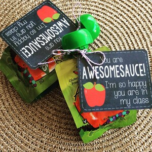 May include: Two small pouches of apple sauce with a chalkboard tag tied to them. The tag says "You are AWESOMESAUCE! I'm so happy you are in my class".