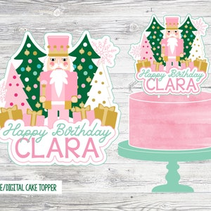 Op de afbeelding: Printbare taarttopper met een roze en groene Notenkraker-thema met een roze en gouden cadeaudoos, een roze kerstboom en de tekst "Happy Birthday CLARA".