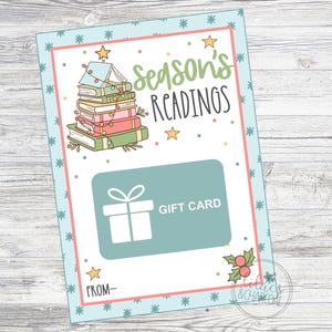 May include: A blue and white gift card with a stack of books decorated with lights and stars. The text on the card reads "Season's Readings" and "Gift Card".