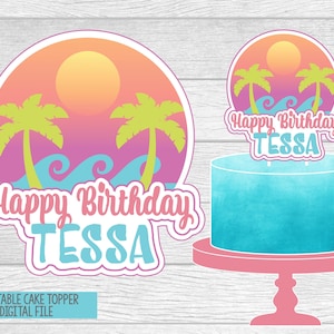 May include: A printable cake topper design with a tropical theme. The design features a sunset, palm trees, and ocean waves, with the text "Happy Birthday TESSA". A blue cake is displayed on a pink cake stand.