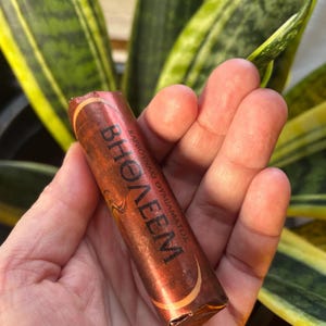 Peut inclure: Un tube brun et or avec le mot "BHOELEM" imprimé en lettres noires. Le tube est étiqueté "КАРБОТОВИК ГИМНАСТОК".