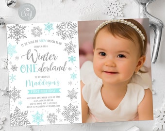 May include: A winter-themed invitation with a photo of a baby girl. The invitation features silver glitter snowflakes and the text "Winter ONEderland" in silver and teal. The baby is wearing a white dress and a pearl headband.