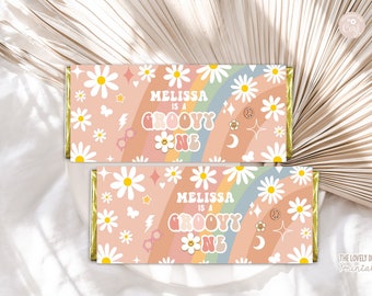May include: Two pink and white chocolate bar wrappers with a rainbow, daisies, and stars. The text on the wrappers reads "Melissa is a groovy one".