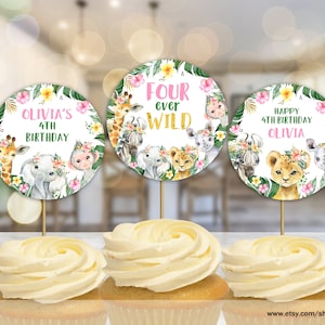 Peut inclure: Trois décorations rondes pour cupcakes sur le thème de la jungle. Les décorations représentent une girafe, un éléphant et un lion avec des accents floraux. Le texte sur les décorations est "Olivia's 4th Birthday", "Four Ever Wild" et "Happy 4th Birthday Olivia".