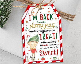 May include: A red and white striped gift tag with a cartoon elf holding a candy cane. The tag says "I'm back from the North Pole and brought you a treat! I'll be reporting to Santa each day... so remember to be sweet!"