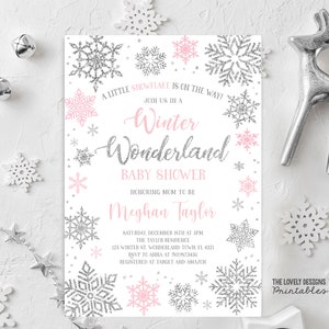 May include: A pink and silver baby shower invitation with a snowflake design. The text reads "A little snowflake is on the way! Join us in a Winter Wonderland Baby Shower Honoring Mom to be Meghan Taylor. Saturday, December 15th at 5pm The Taylor Residence 125 Winter St, Wonderland Town, FL 4321 RSVP to Anna at 759.987.3456 Registered at Target and Amazon. The Lovely Designs Printables."