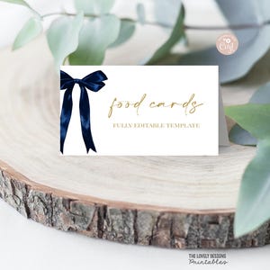 May include: White food card with navy blue ribbon and gold text that reads "food cards" and "FULLY EDITABLE TEMPLATE". The card is on a wooden surface. The Lovely Designs Printables logo is in the bottom right corner.