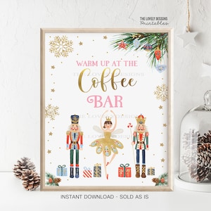 May include: A printable sign with a pink and gold design featuring a ballerina and two nutcracker figures. The sign reads "Warm Up At The Coffee Bar".