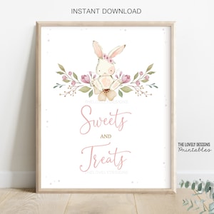 May include: A printable sign with a watercolor illustration of a white bunny wearing a pink flower crown. The bunny is surrounded by pink and green flowers. The sign says "Sweets and Treats" in pink script.