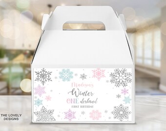 May include: White favor box with a snowflake design and the text "Madison's Winter Wonderland First Birthday".