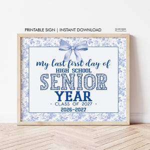 May include: A rectangular sign featuring a light blue floral border and a central blue bow graphic. The text reads: my last first day of HIGH SCHOOL SENIOR YEAR - CLASS OF 2027 - 2026-2027. The sign is framed in light wood and has a white background.