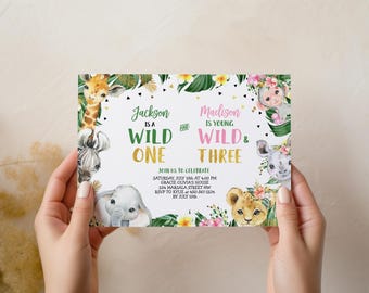 May include: A birthday invitation with a jungle theme. The invitation features watercolor illustrations of a giraffe, zebra, elephant, lion, rhino, and monkey. Text reads "Jackson is a Wild One" and "Madison is young, Wild & Three."