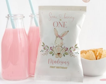 以下が含まれることがあります： ピンクのウサギのイラストと「Some bunny is ONE」と「Madison's First Birthday」の文字が書かれた白いチップ袋。
