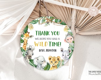 May include: Round thank you tag with a jungle theme. It features a giraffe, zebra, elephant, lion, and monkey surrounded by green leaves and gold accents. The text reads "Thank you, we hope you had a wild time! Love, Brayden."