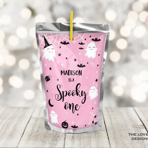 Könnte beinhalten: Rosa-weißer Saftbeutel mit Halloween-Motiv. Er zeigt Geister, Fledermäuse, Sterne und Spinnen. Der Text lautet "Madison is a Spooky One".