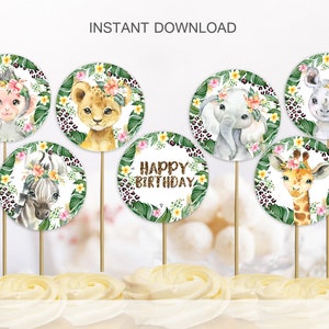May include: Watercolor cupcake toppers featuring safari animals: monkey, lion, elephant, rhino, zebra, and giraffe. Each animal is surrounded by a floral wreath and leopard print. One topper says "Happy Birthday".