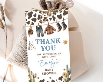 Könnte beinhalten: Ein Dankeschön-Etikett für eine Babyparty mit Cowboy-Thema. Das Etikett zeigt einen braunen und weißen Kuhfleckenhintergrund mit einer blauen und weißen Wäscheleine, an der Babykleidung hängt. Der Text auf dem Etikett lautet "Vielen Dank, dass Sie uns mit Liebe überschüttet haben Emily's Babyparty".